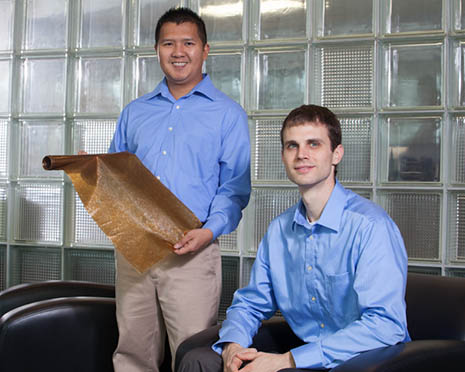 Nhiem Cao (left), president and CEO of cycleWood Solutions Inc., and company co-founder Kevin Oden pose with their film sample of a biodegradable plastic. Photo by Russell Cothren, University of Arkansas.